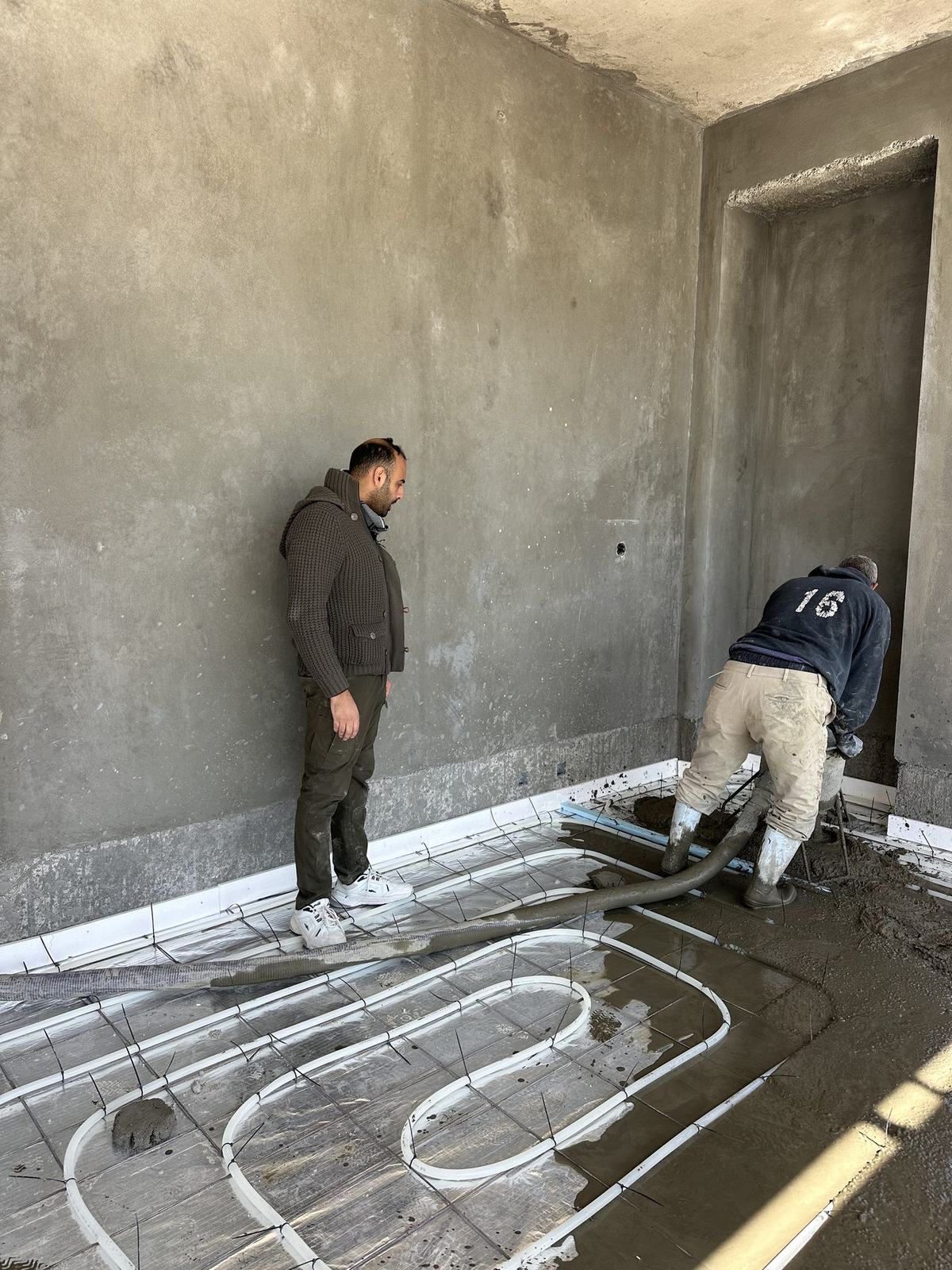 Supervising the screed pour over heating pipes
