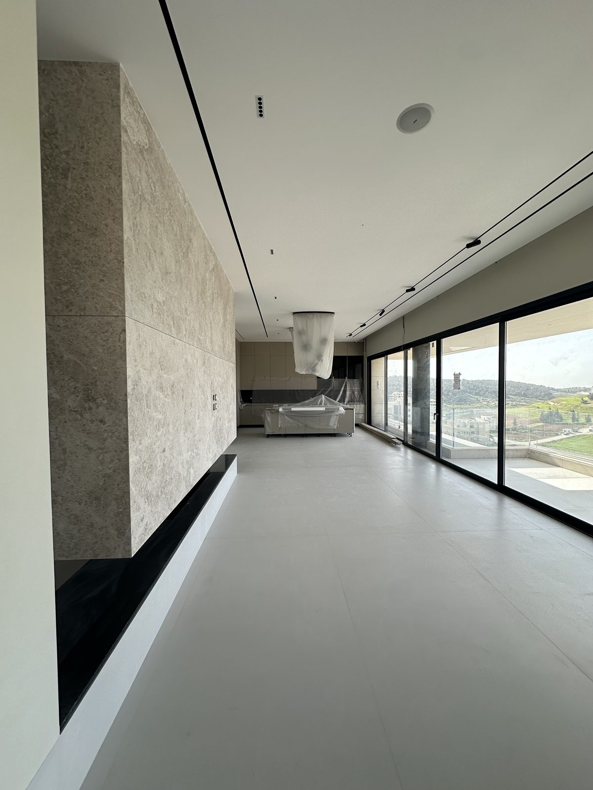 Living room with stone feature wall and full-height glazing