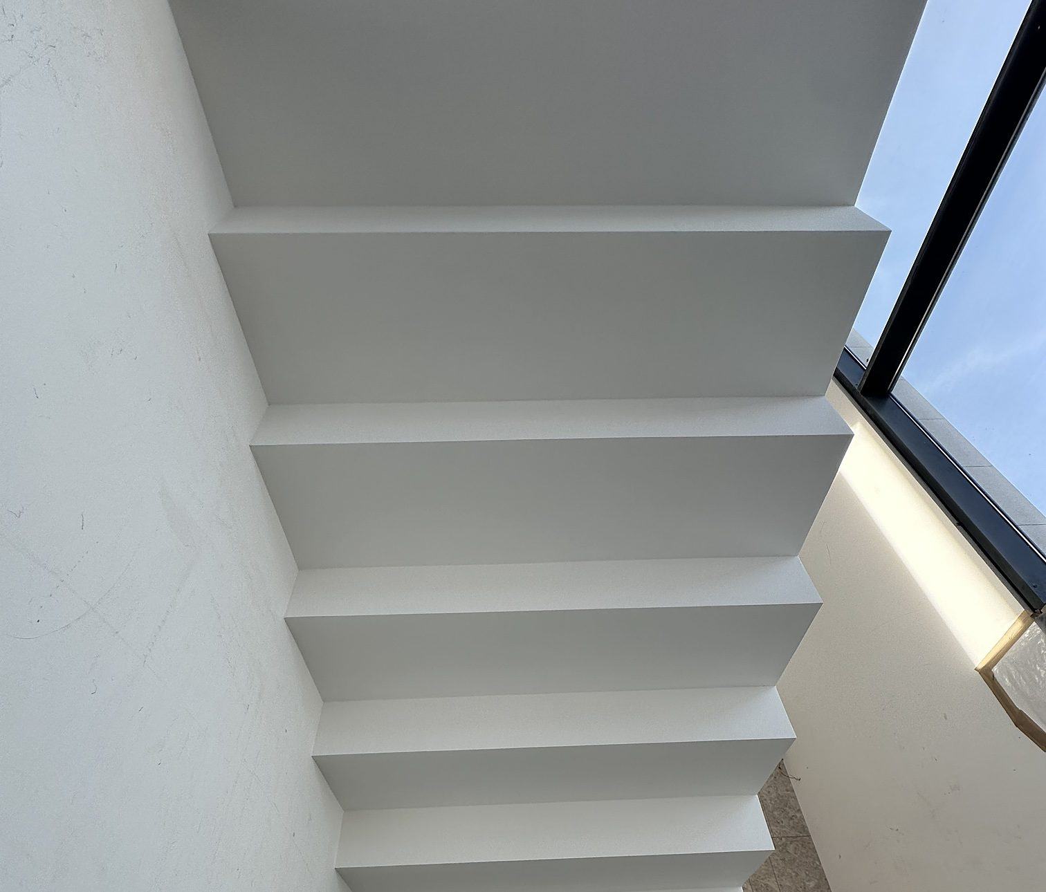 Cantilevered staircase in white plaster