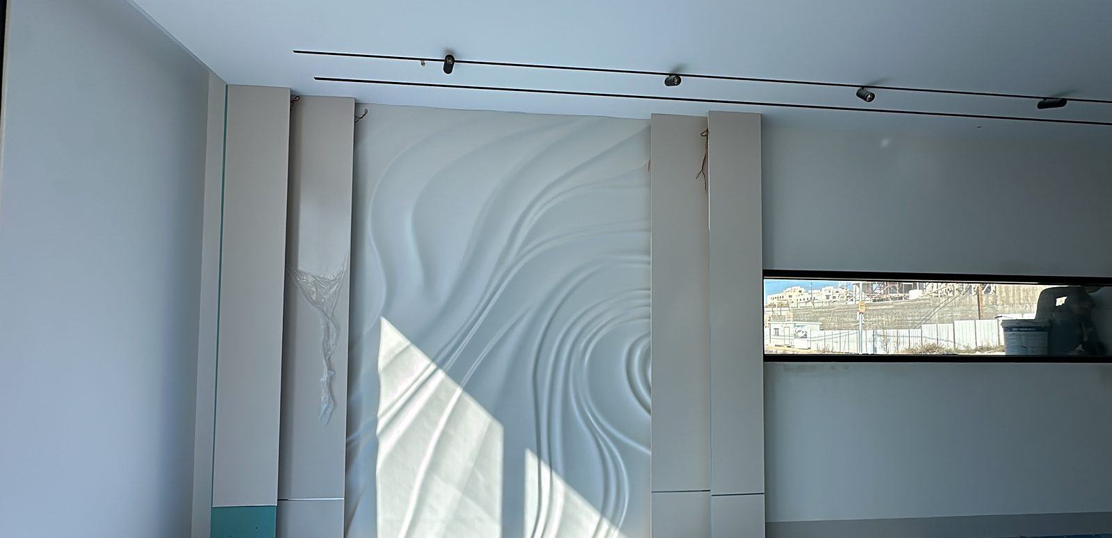 Sculpted wave wall with track lighting