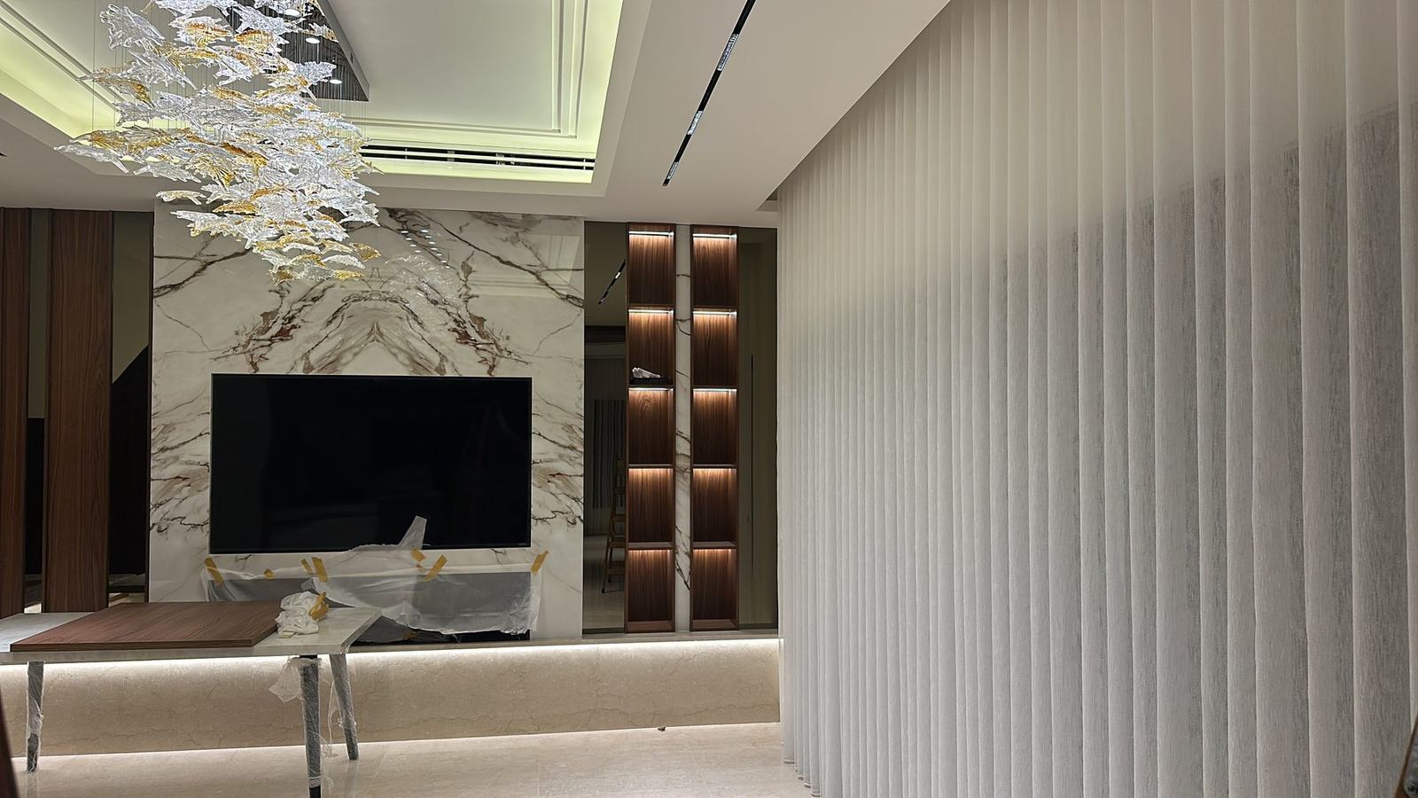 TV wall in bookmatched marble with timber shelving